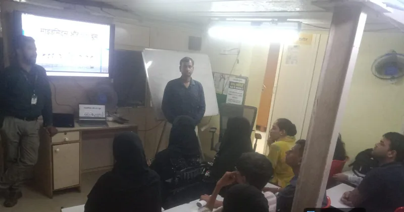 Trainer at a whiteboard beside a projected slide while learners sit at desks in a MindMints classroom