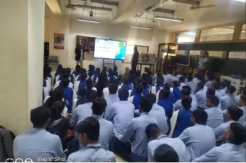 A hall full of young people in uniform during a counselling session led by the MindMints CEO and Chief Business Officer